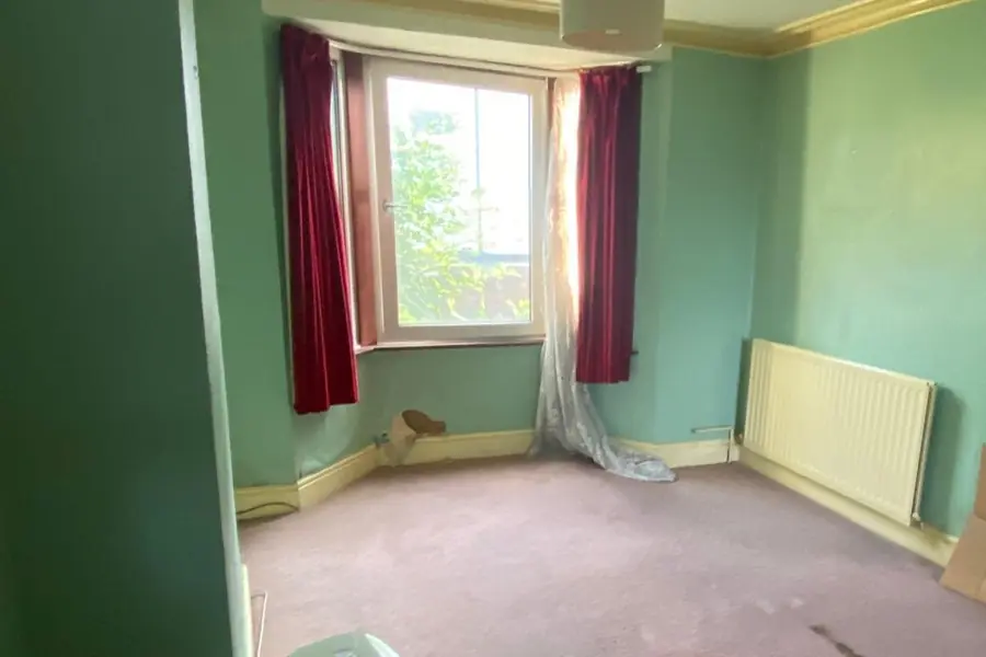 Before: a room with green walls, old carpet and a bay window